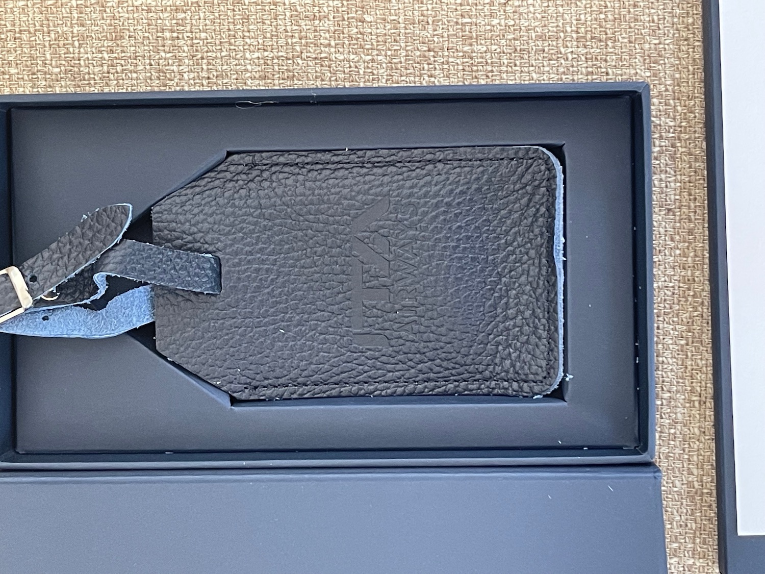 a black leather luggage tag in a box