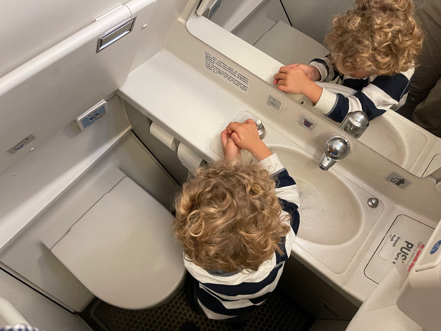 a child washing hands in a bathroom