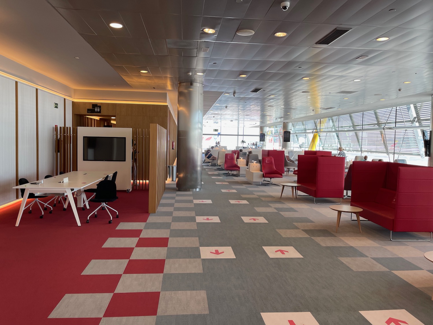 a room with red and white checkered carpet and tables and chairs