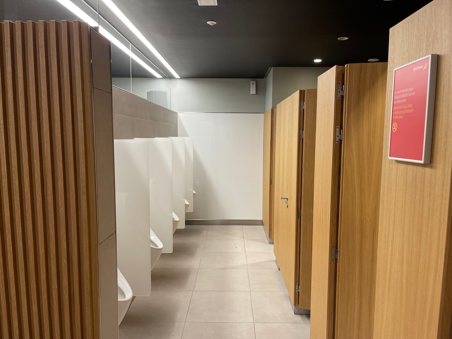 a bathroom with urinals and wooden doors