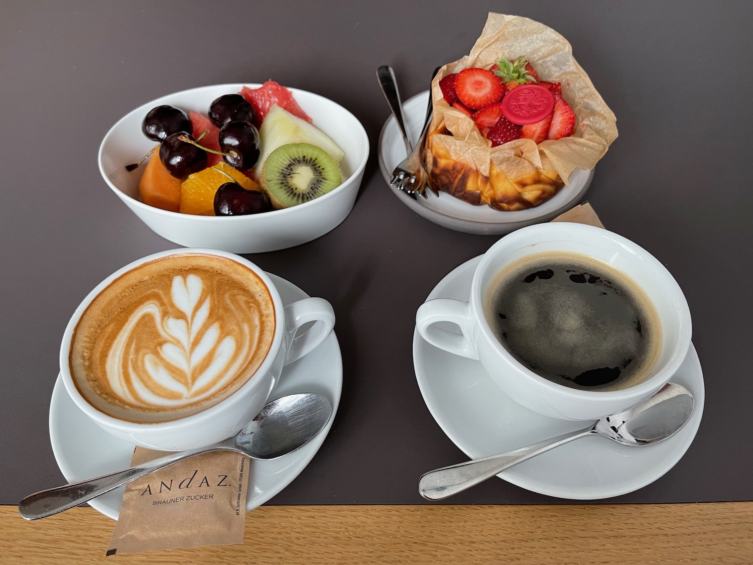 a group of cups of coffee and fruit on plates