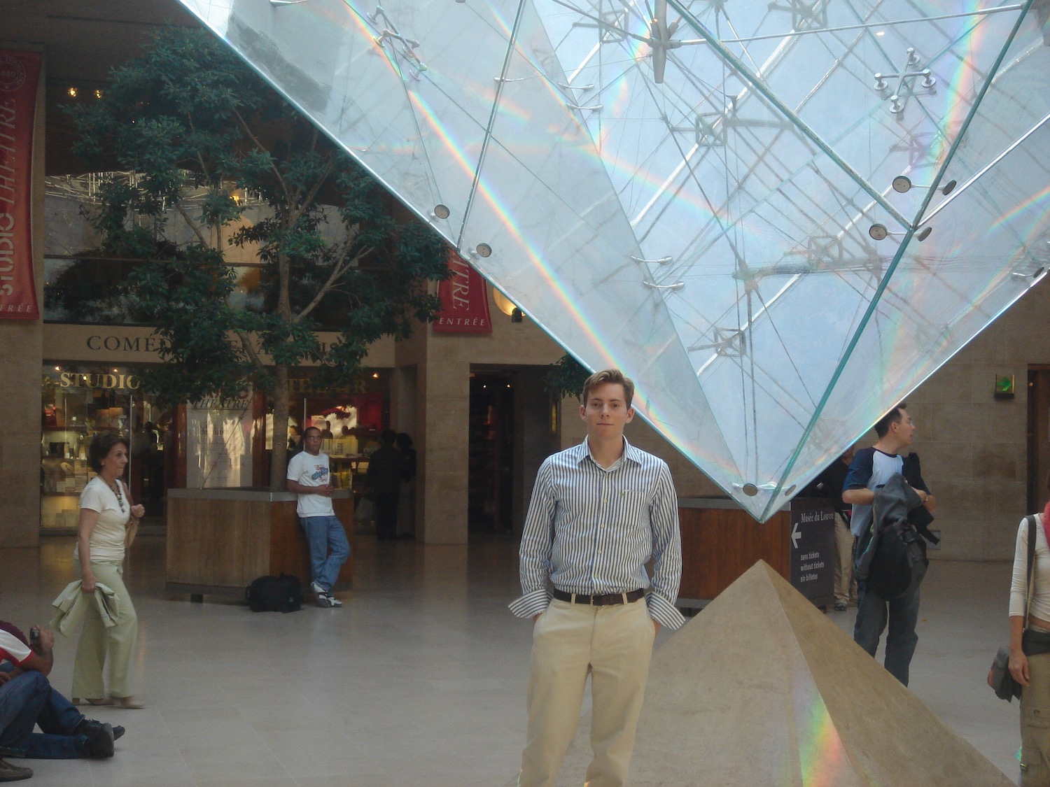 a man standing in a building with a glass pyramid