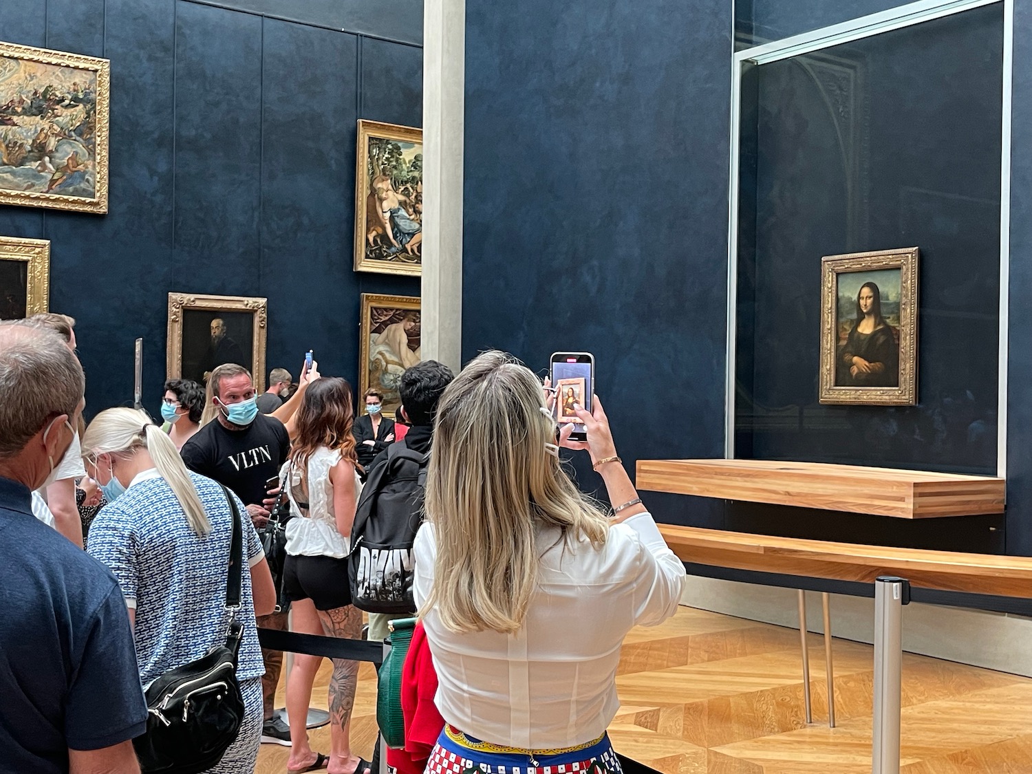 a woman taking a picture of a painting