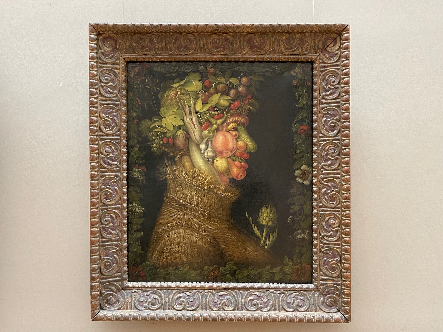 a framed painting of a woman with fruits