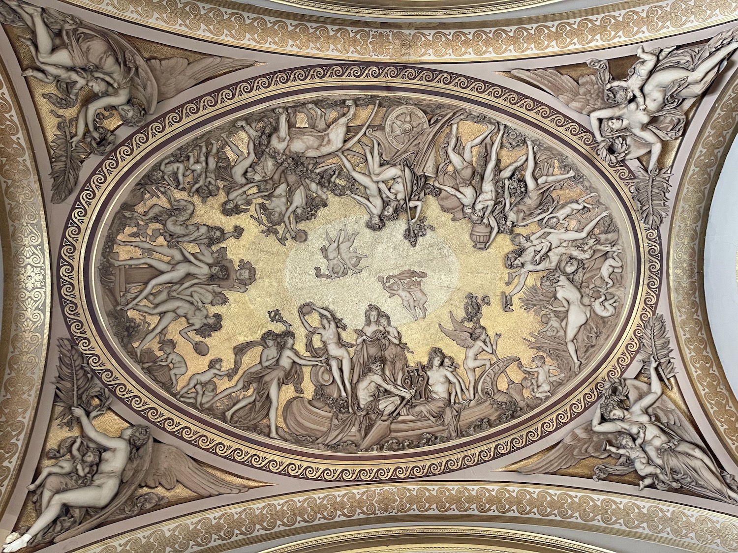 a ceiling with a gold and white ceiling with statues