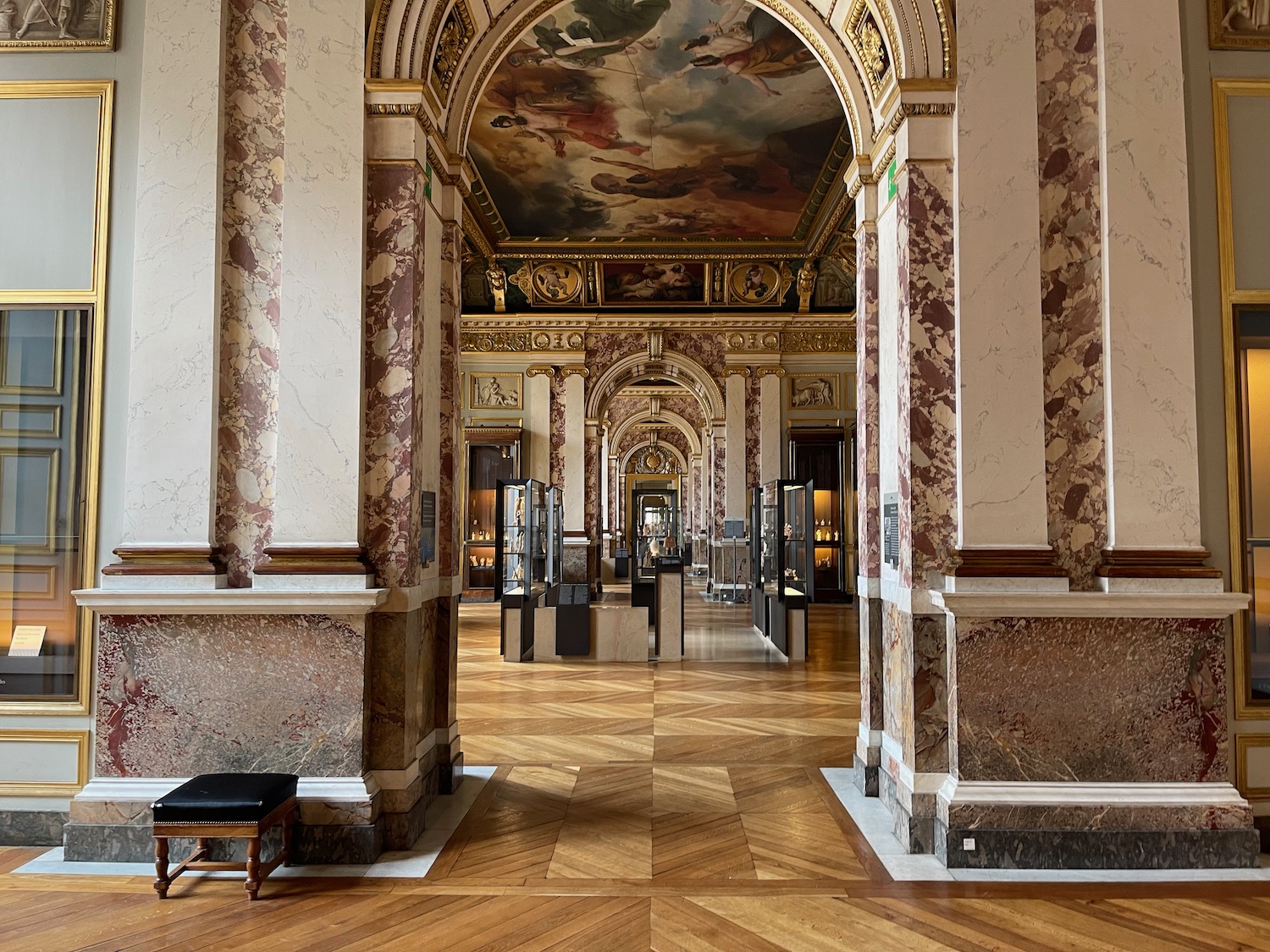 a large ornate building with marble columns and a painting