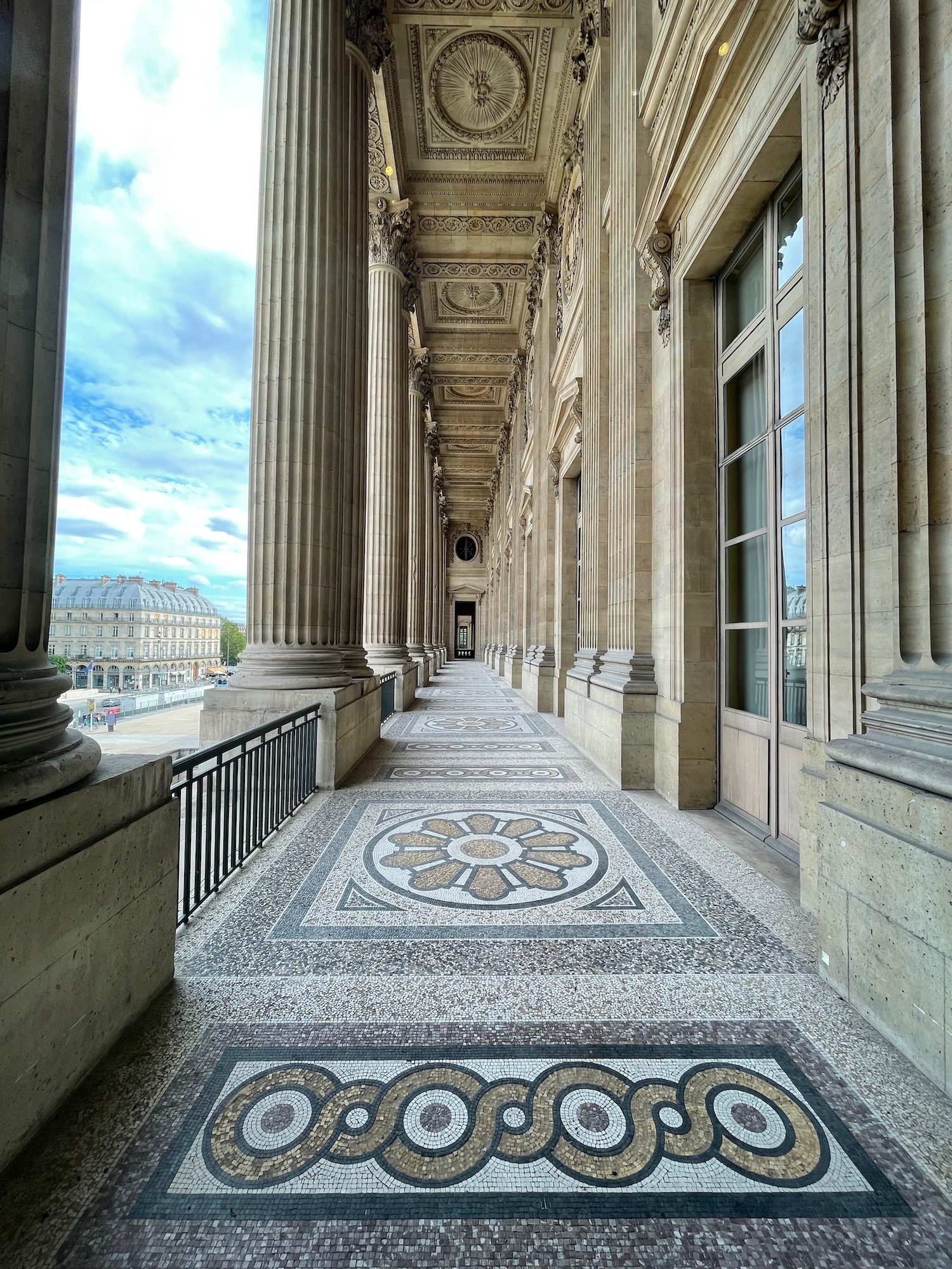 a stone walkway with columns and a stone walkway