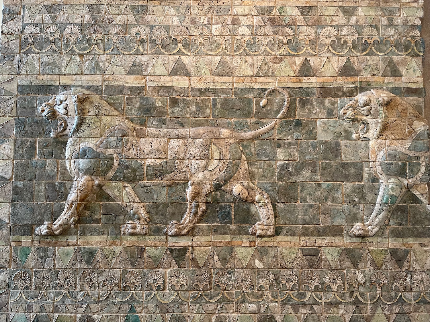 a stone wall with a lion and a lioness