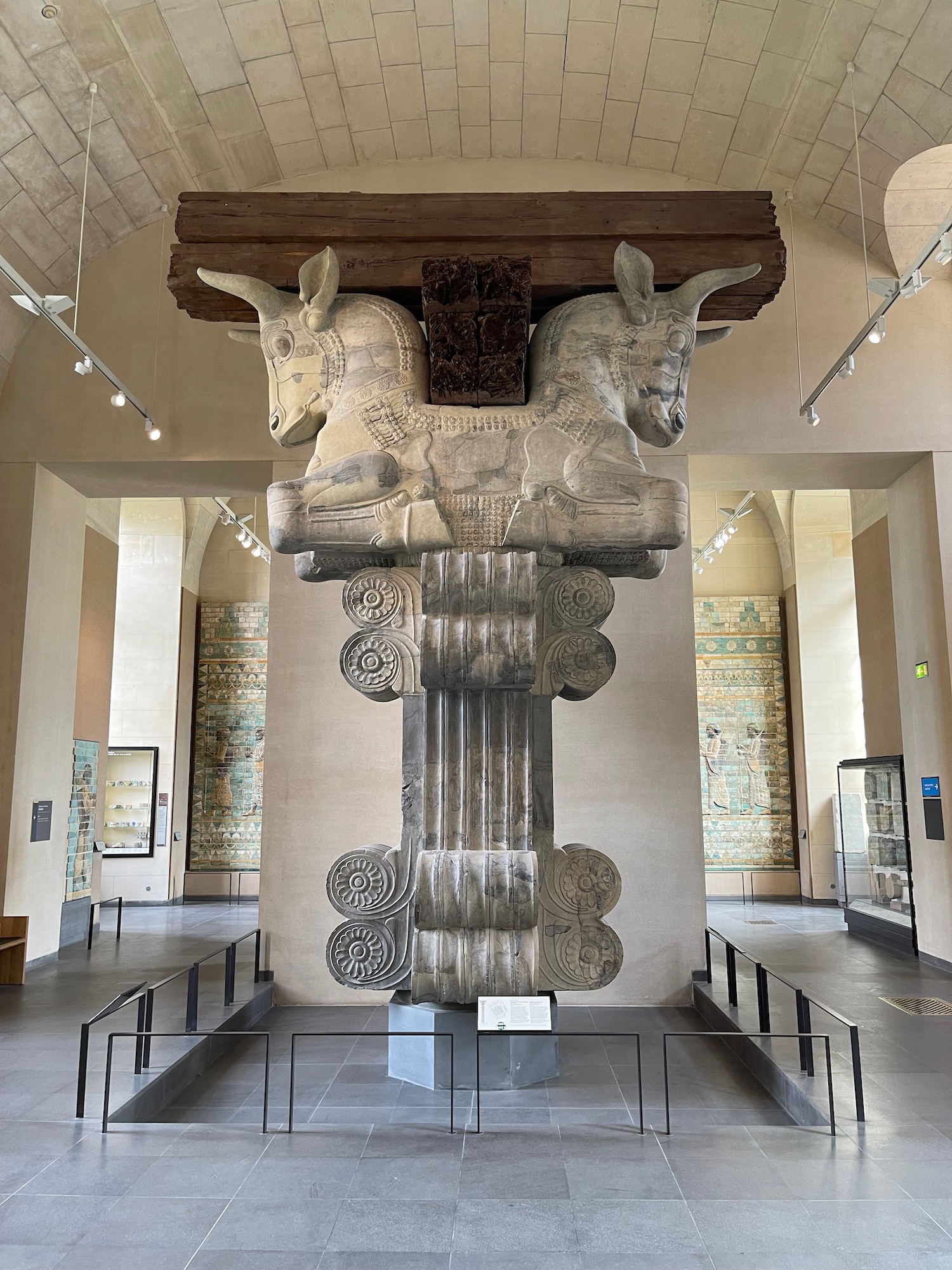 a statue of two animals on a column in a room with a glass case