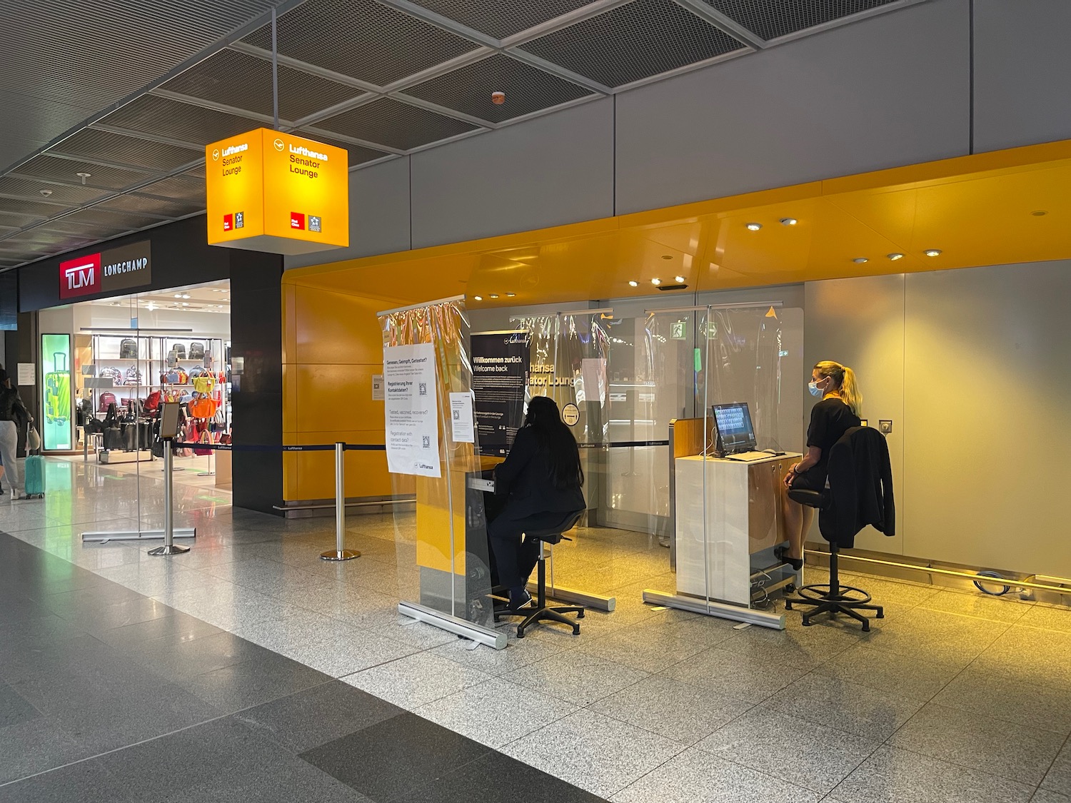 people in a building with a yellow sign and a woman sitting at a desk