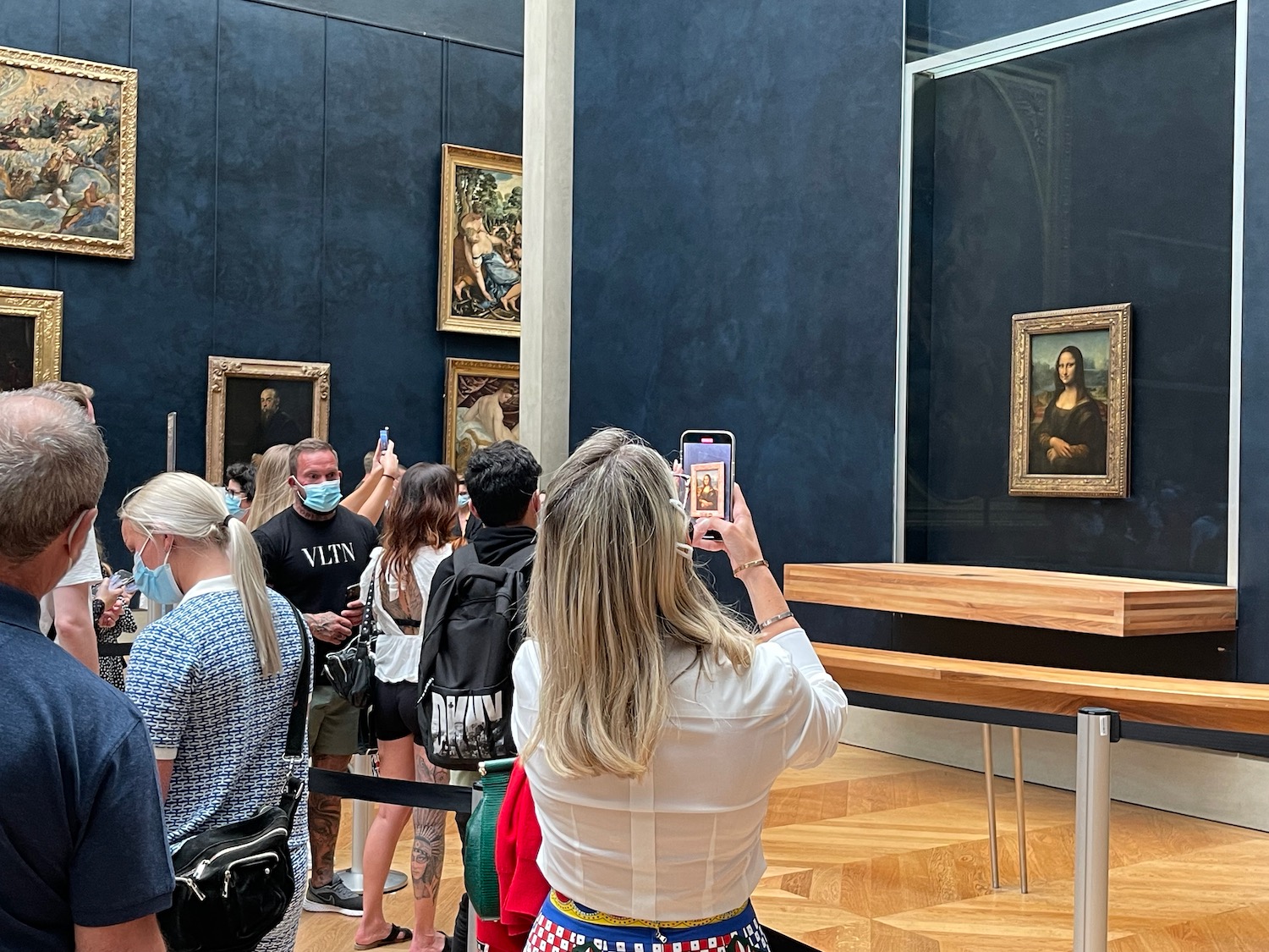 a woman taking a picture of a mona lisa