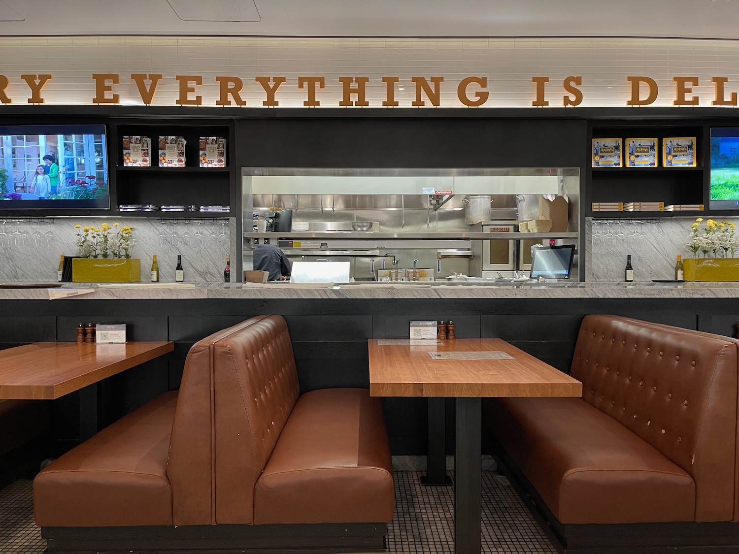 a restaurant with brown booth seating and a counter