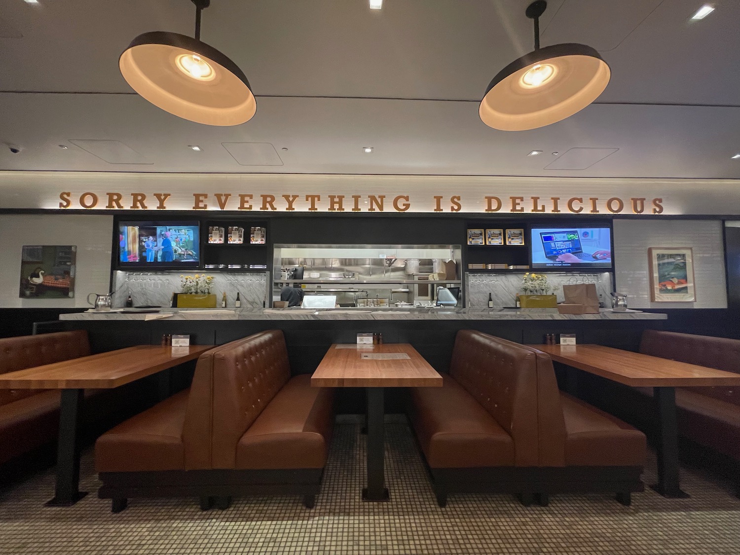 a restaurant with brown booth seats and a tv