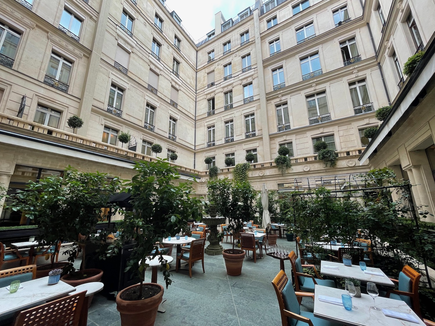 a courtyard with tables and chairs and plants