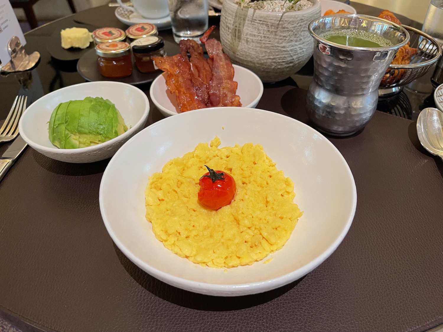 a bowl of scrambled eggs with a tomato on top