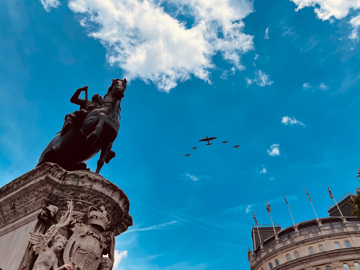 a statue of a man on a horse and planes flying in the sky