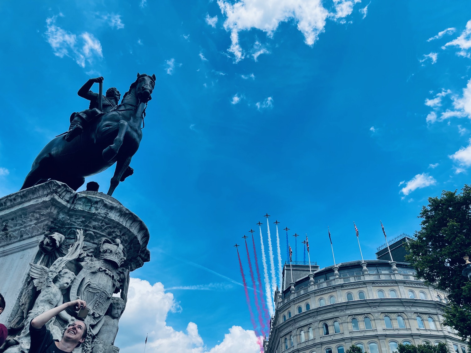 a woman taking a selfie with a statue of a man on a horse