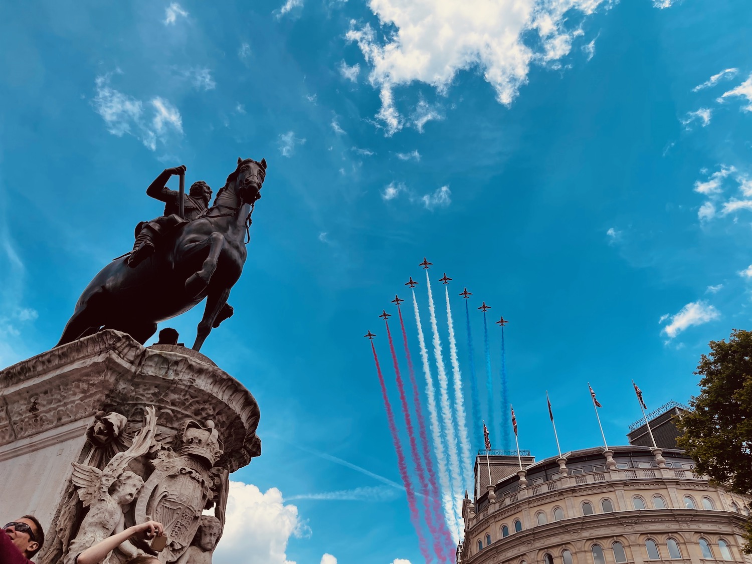 a statue of a man on a horse with red white and blue jets flying in the sky