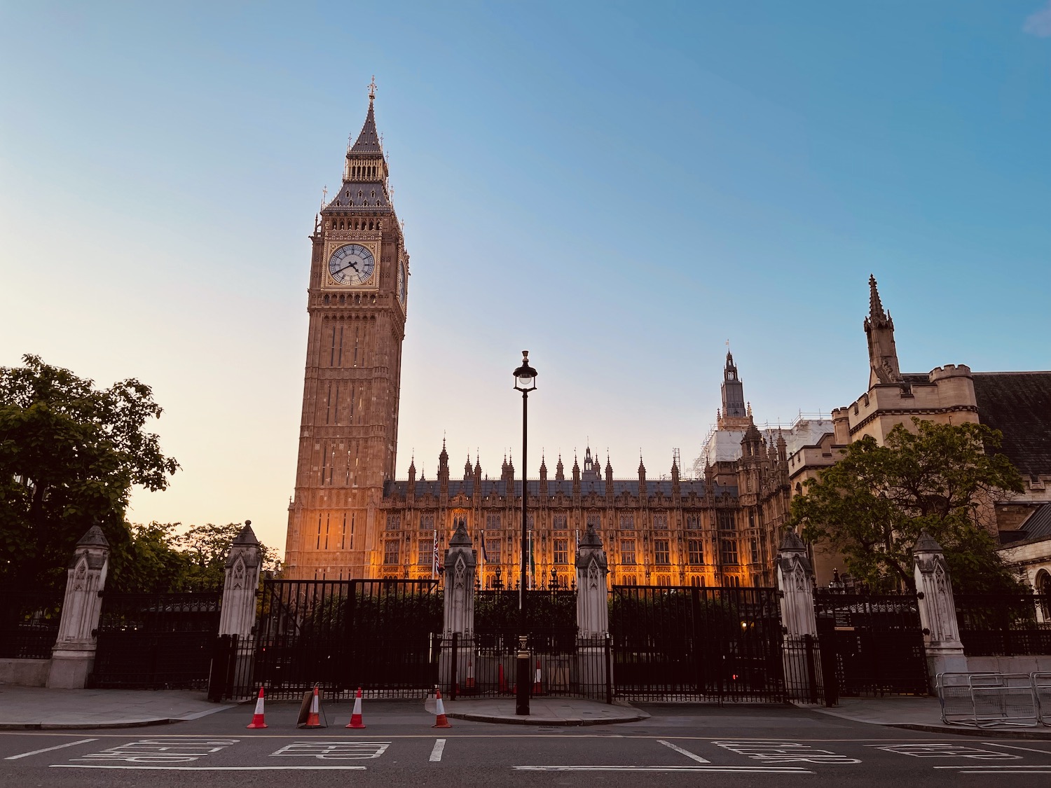 a clock tower in front of a fence