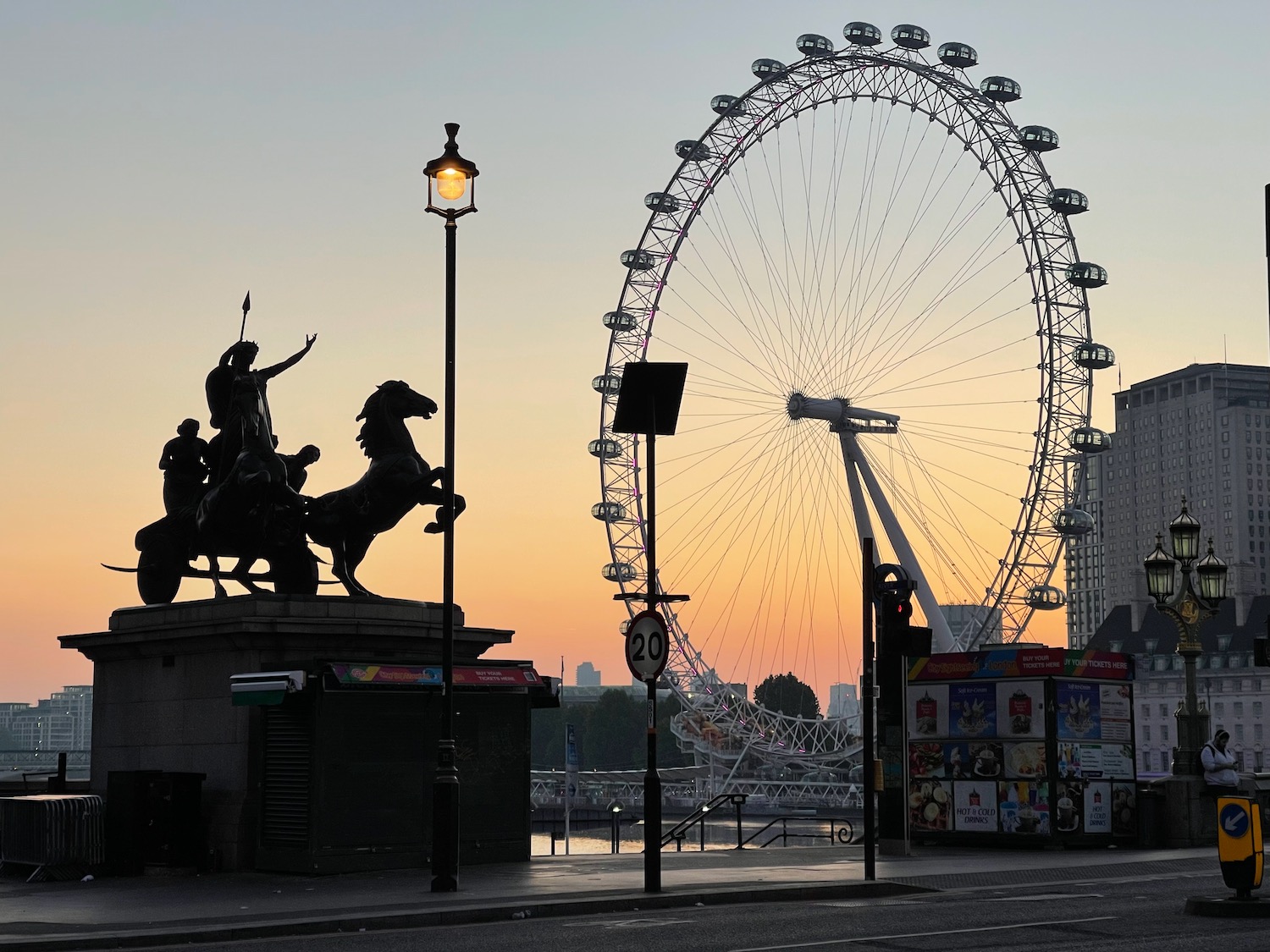 a statue of a man riding a horse and a ferris wheel with London Eye in the background