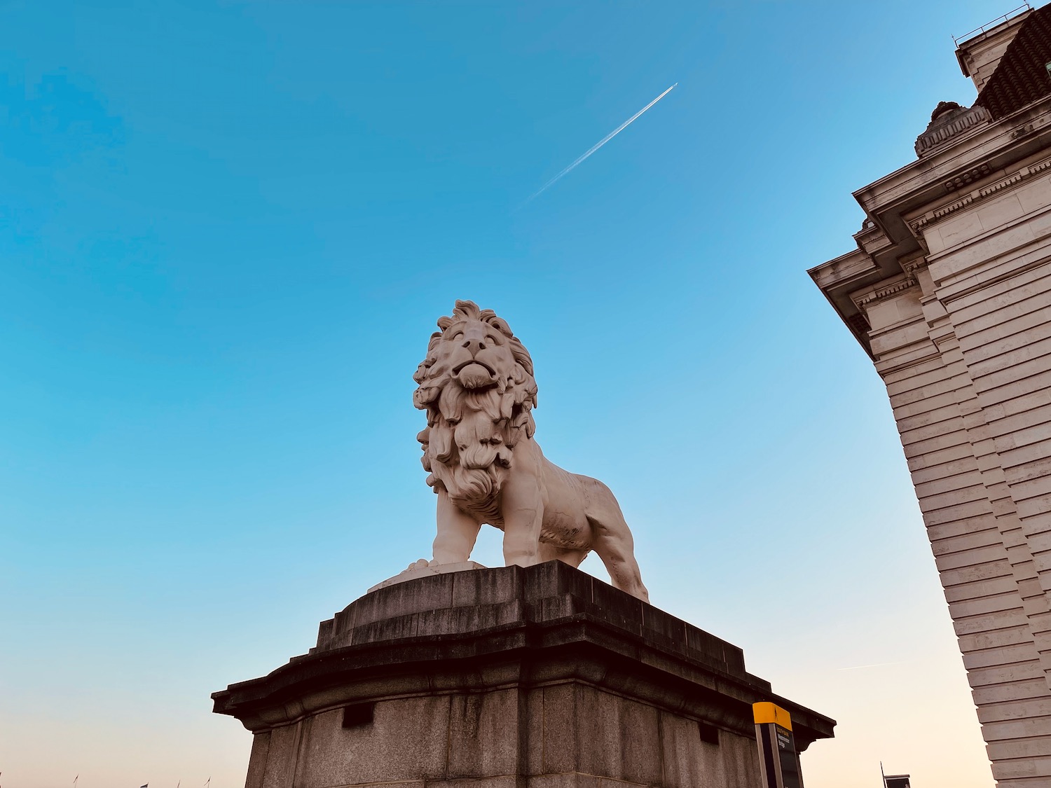 a statue of a lion on a stone pedestal