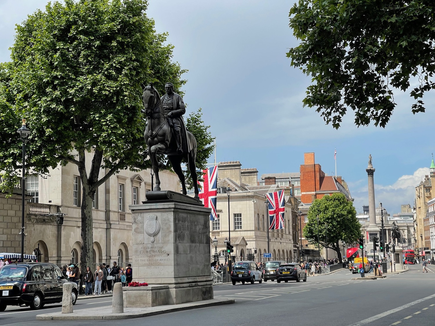 a statue of a man on a horse on a street with people and cars