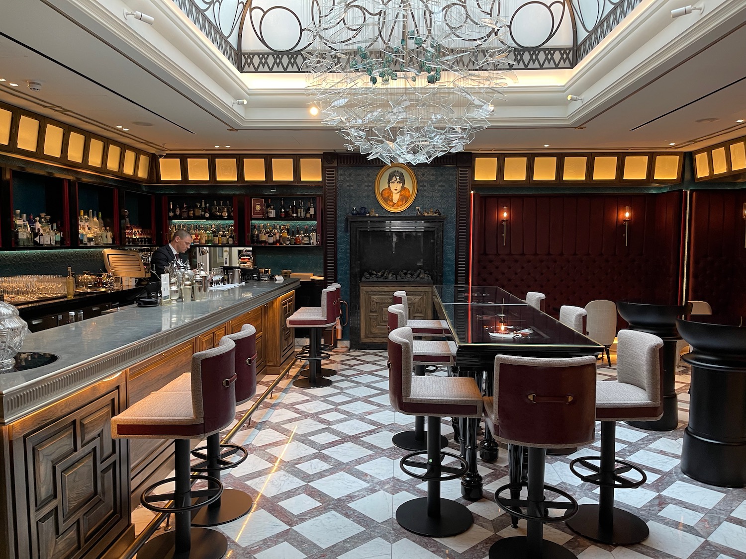 a bar with a glass ceiling and a man sitting at the bar