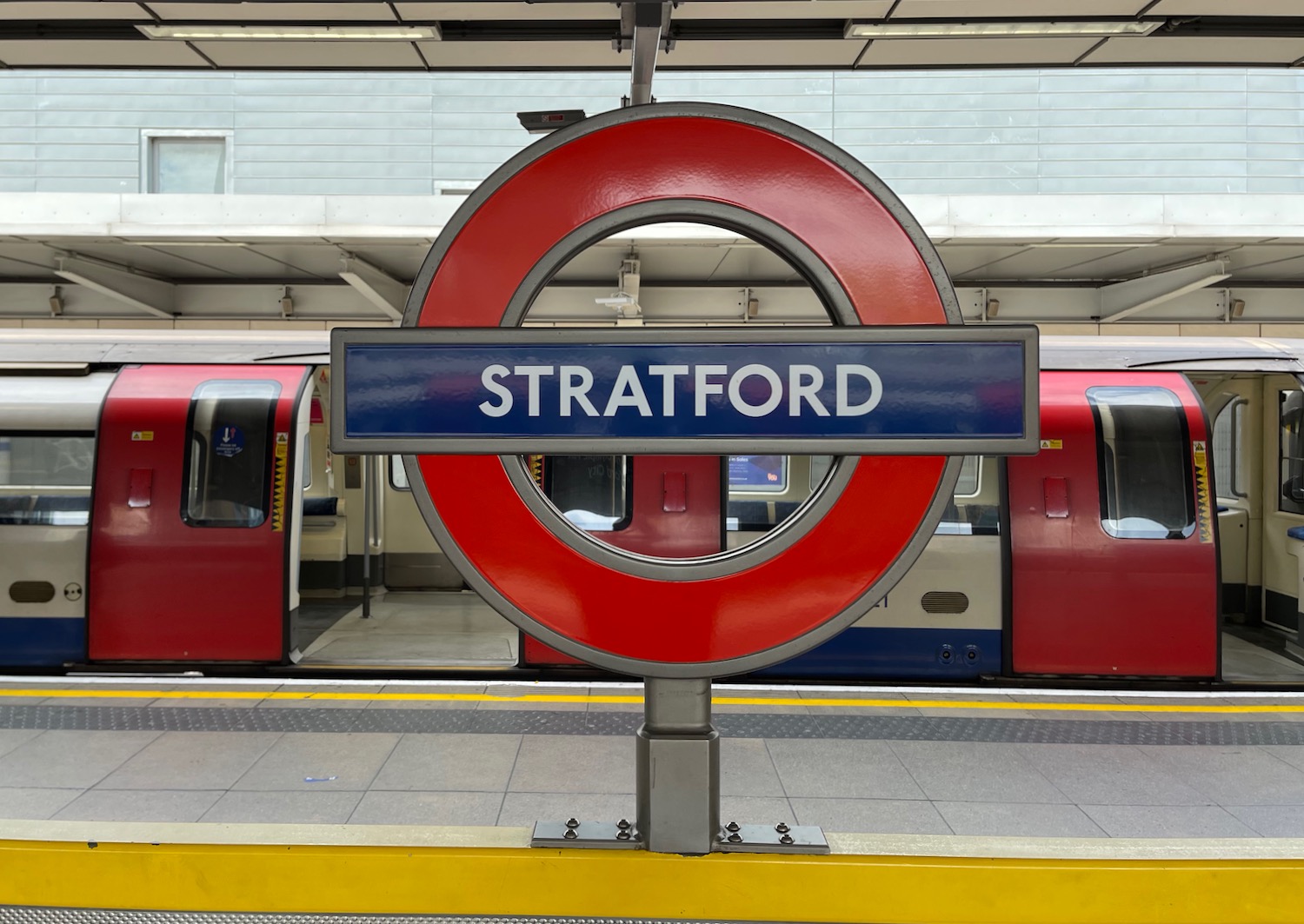 a sign in a station with London Underground in the background