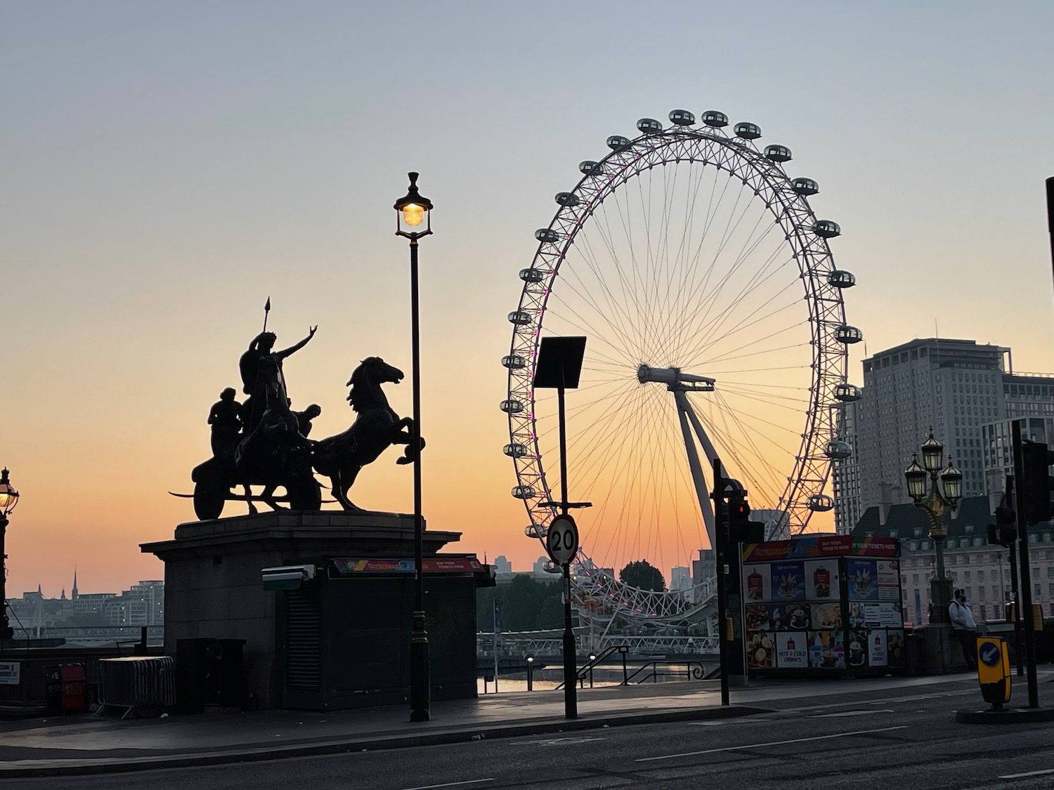 a statue of a man riding a horse and a ferris wheel