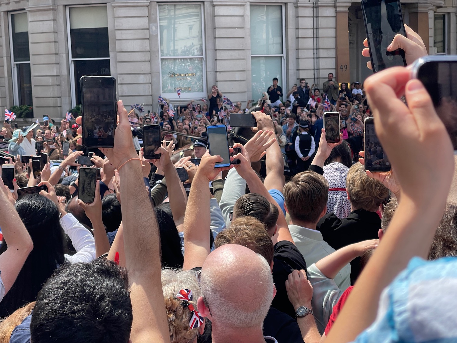 a group of people holding phones in front of a building