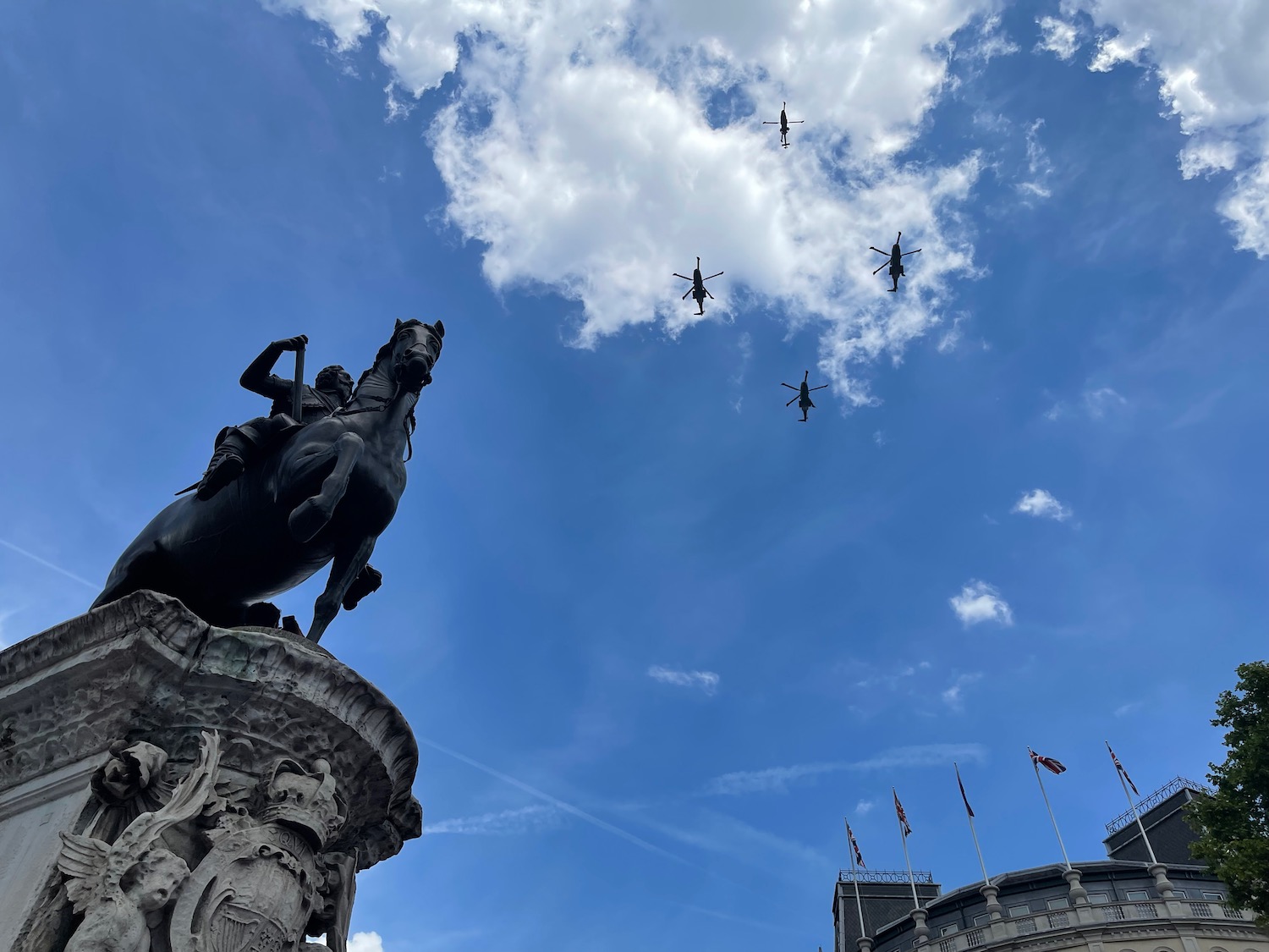 a group of airplanes flying over a statue of a horse