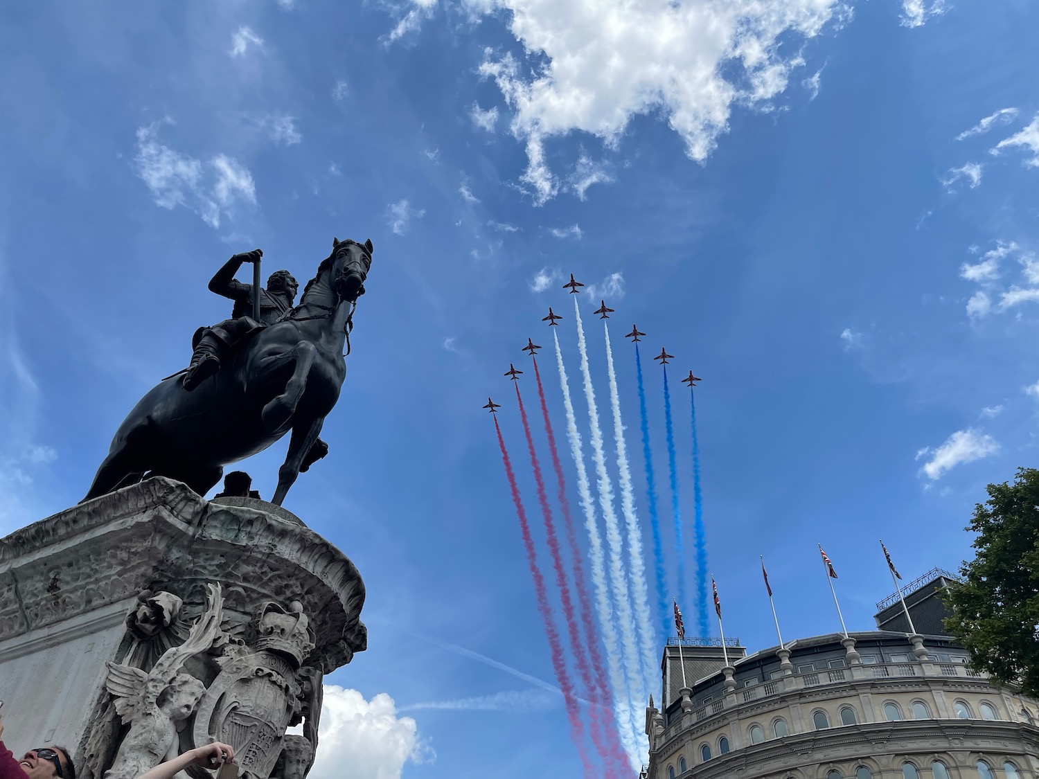 a statue of a man on a horse with red white and blue jets flying in the sky