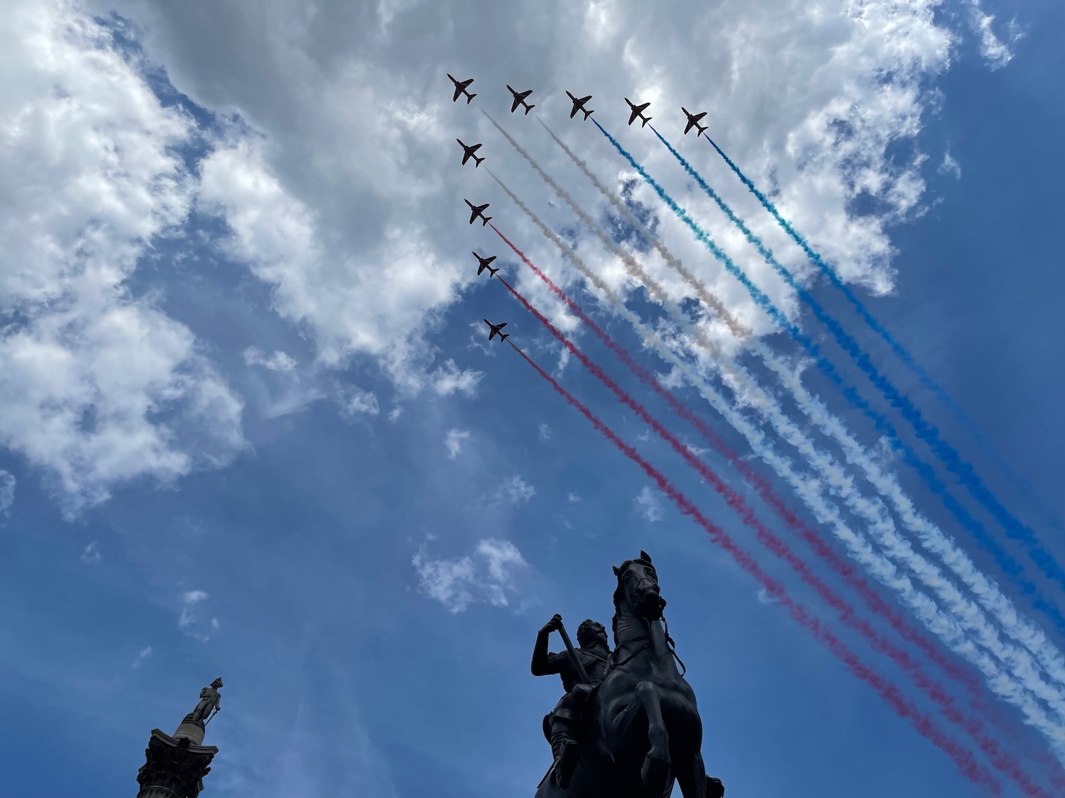 a group of airplanes flying in formation with colored smoke trails