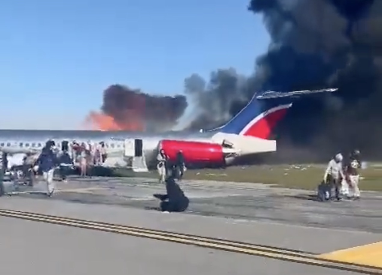 a plane on the runway with smoke coming out of it