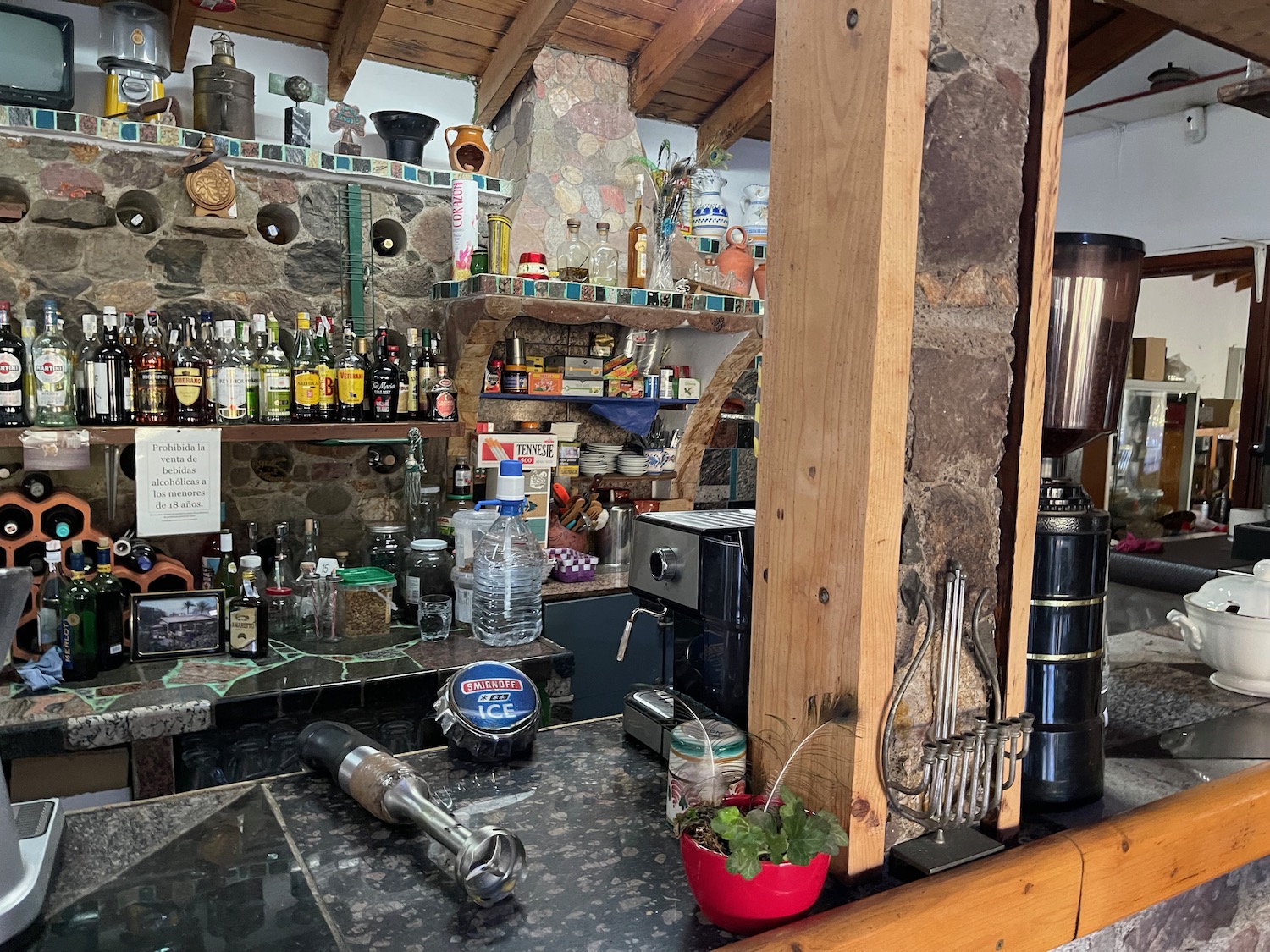 a kitchen with a stone wall and shelves