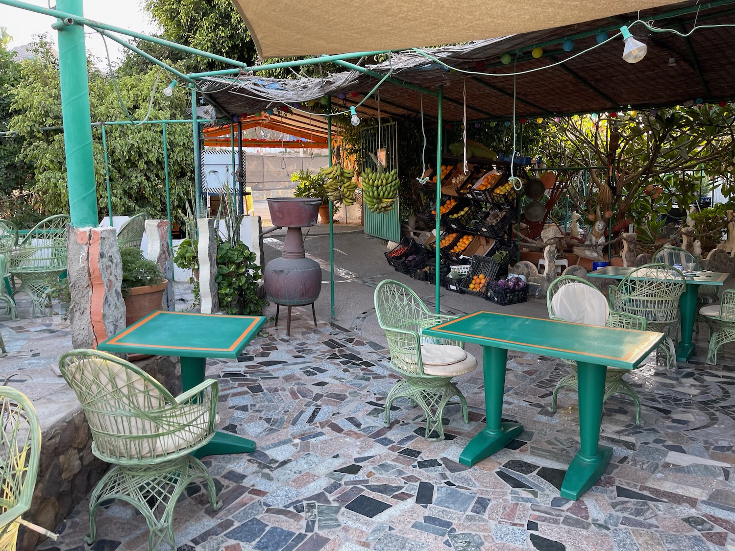 a green table and chairs under a canopy
