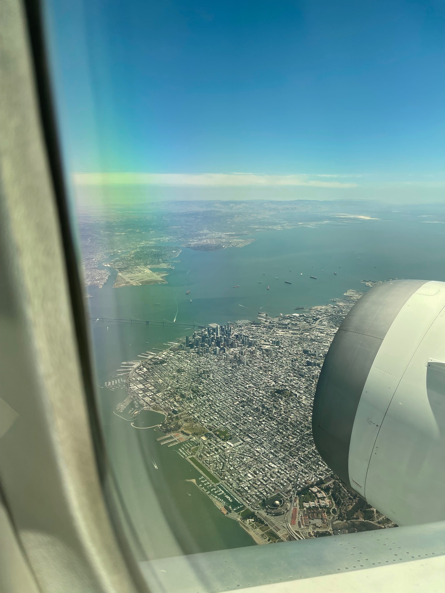 an airplane wing and a city seen from the window of an airplane