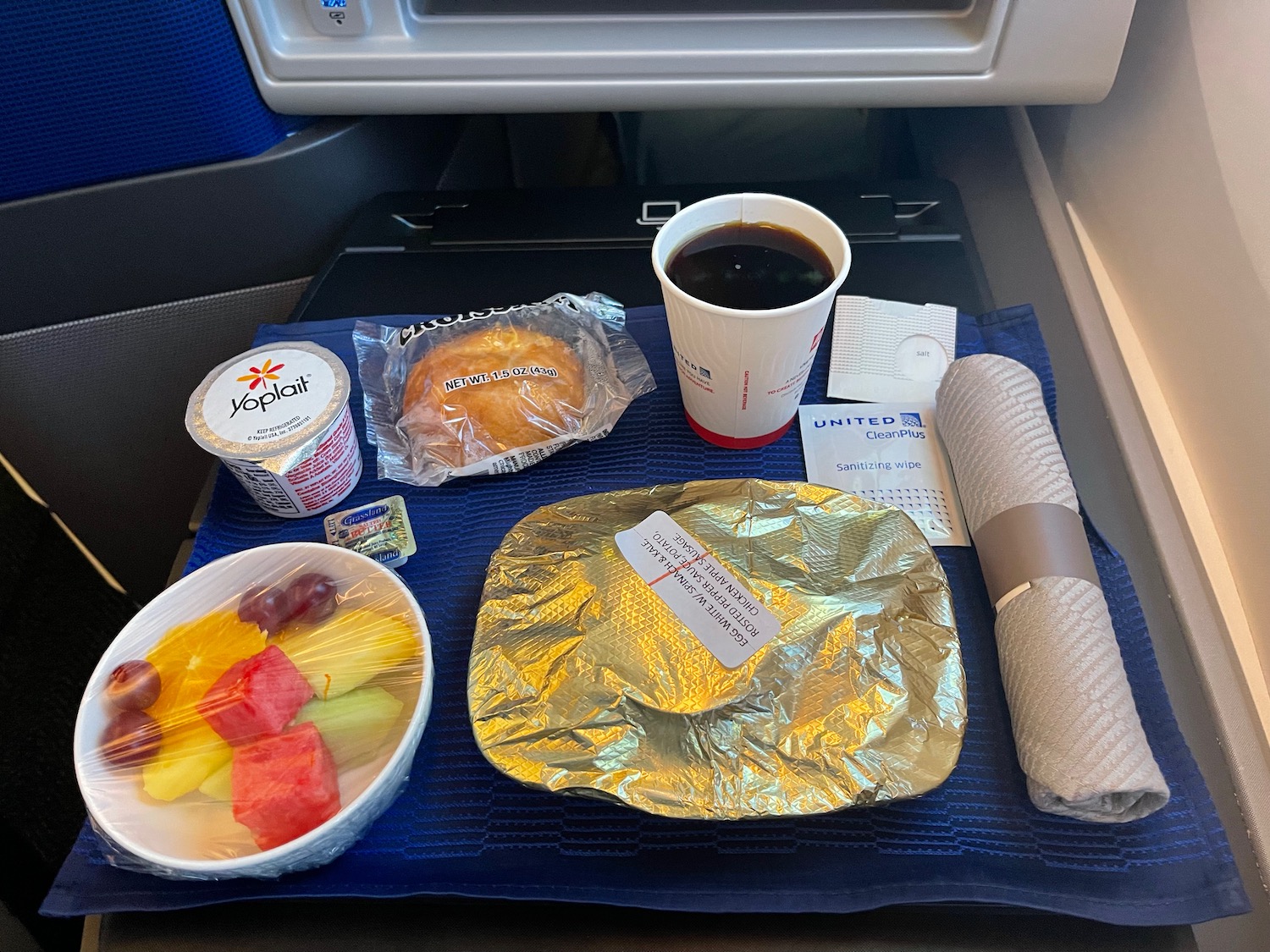 food on a tray with a drink and a cup of coffee