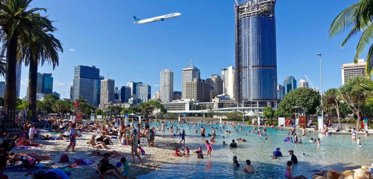 a large group of people in a pool with a city in the background