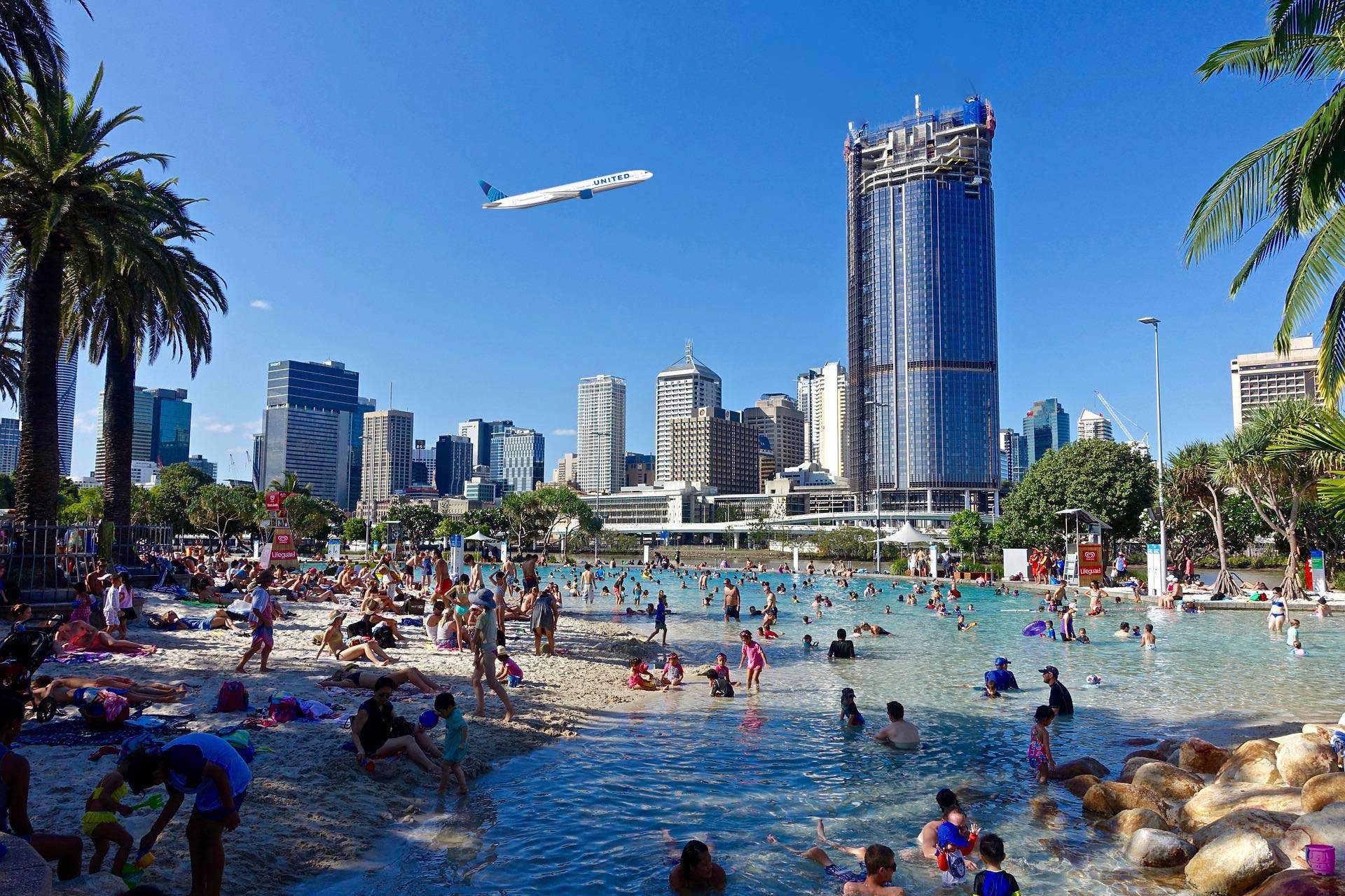a large group of people in a pool with a city in the background
