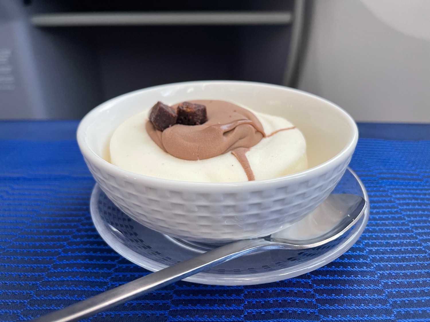 a bowl of ice cream with chocolate and brown topping