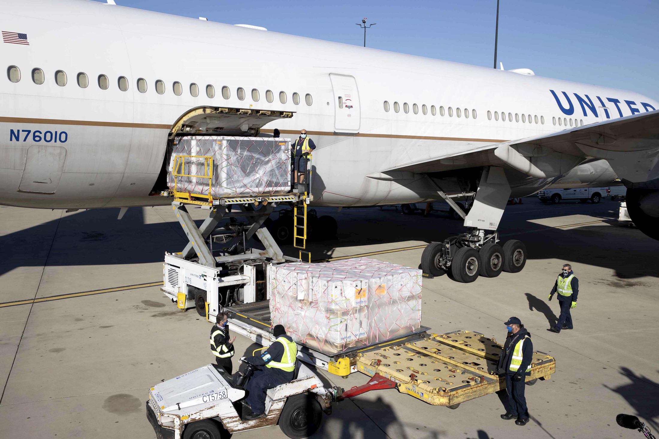 a large airplane with luggage being loaded with luggage