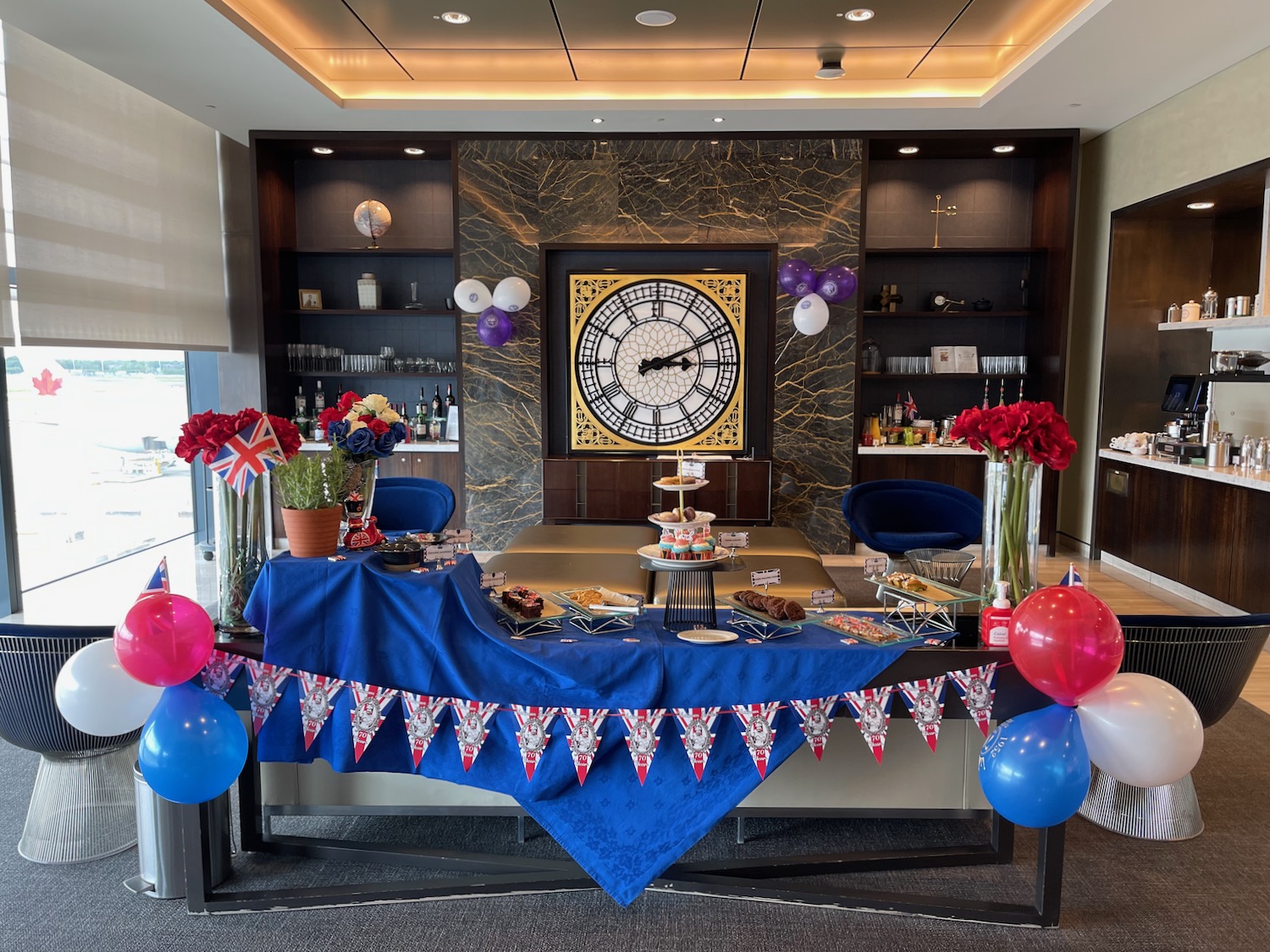 a table with balloons and a clock in the background