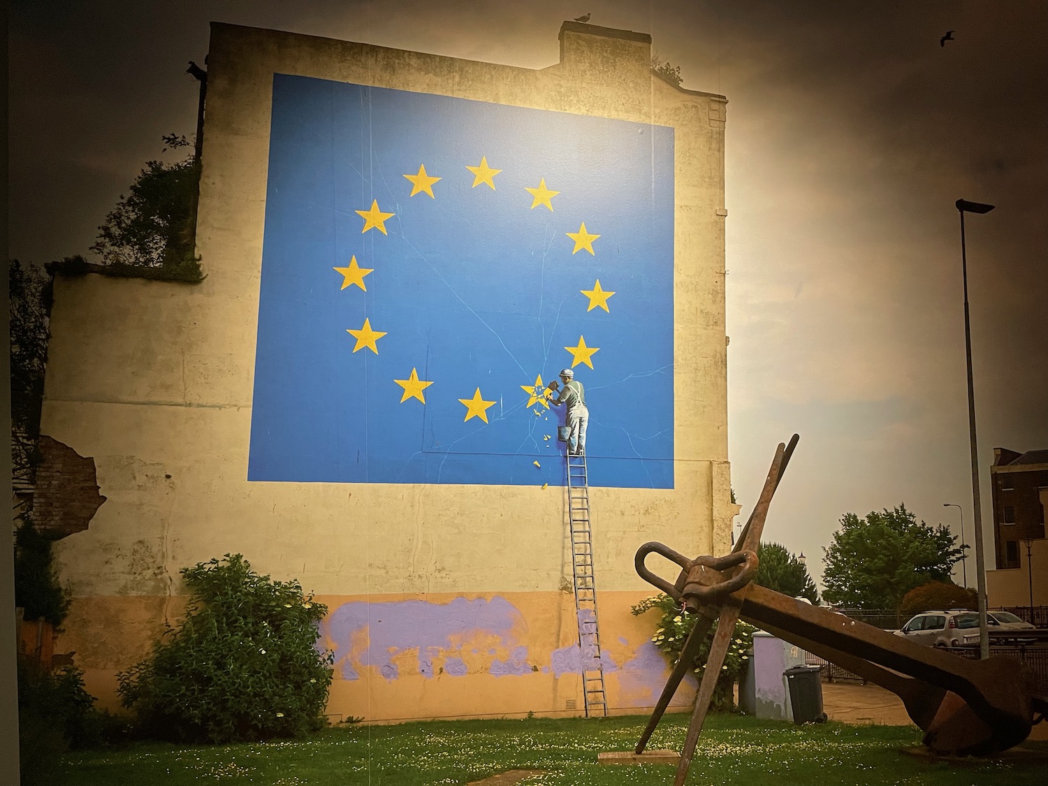 a man on a ladder painting a flag