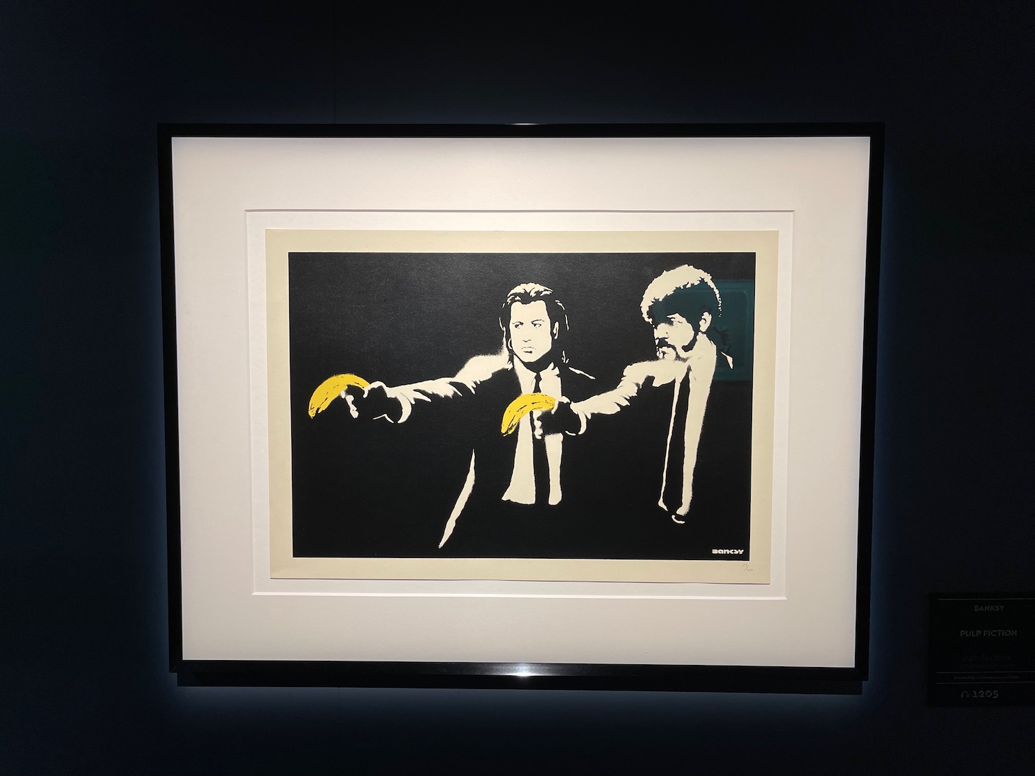 a framed picture of a man pointing a banana