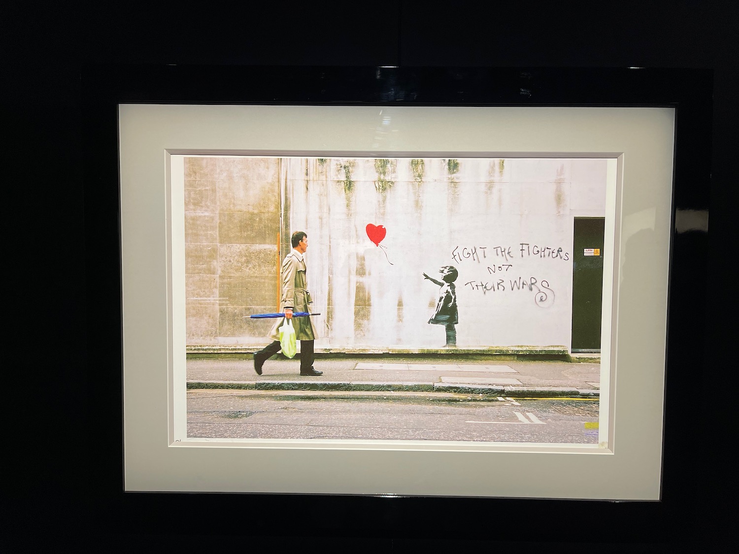 a picture of a man walking on the street with a balloon and a boy