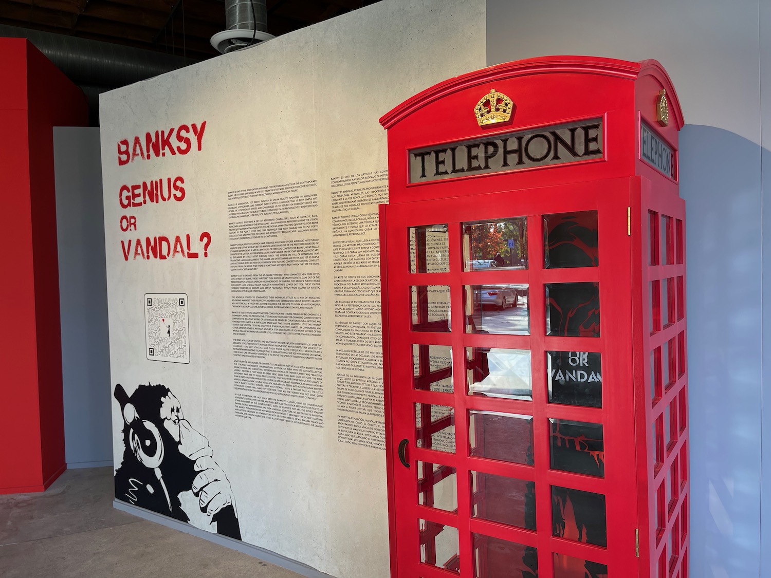 a red telephone booth next to a wall