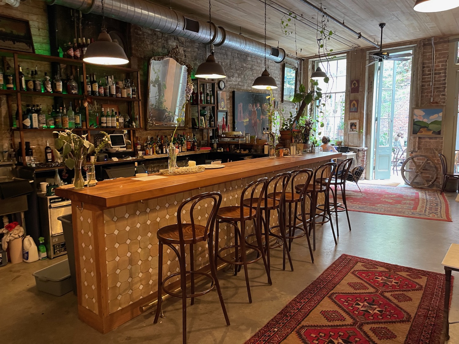 a bar with chairs and a rug in front of it