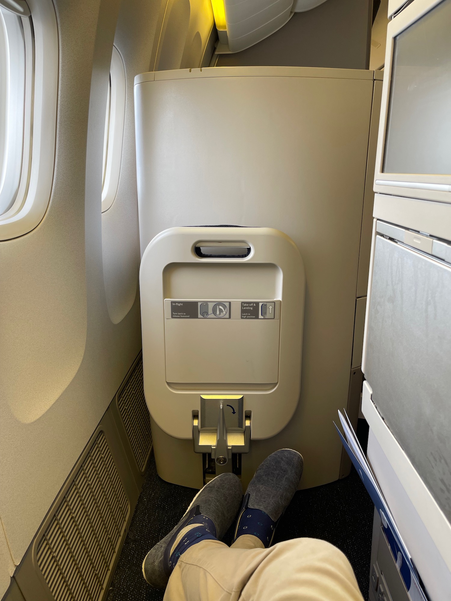 a person's feet in a seat on an airplane