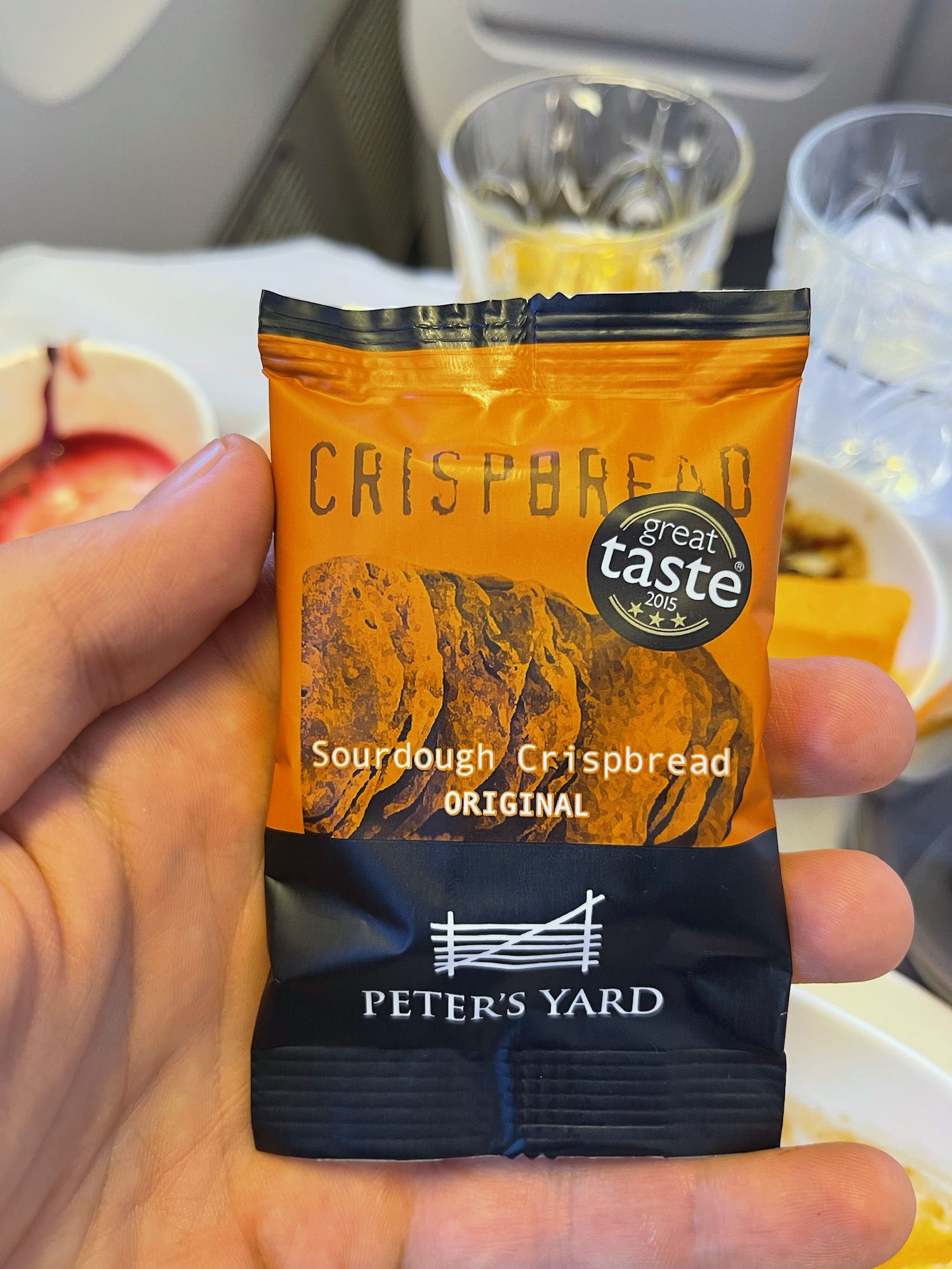 a hand holding a small packet of crispbread